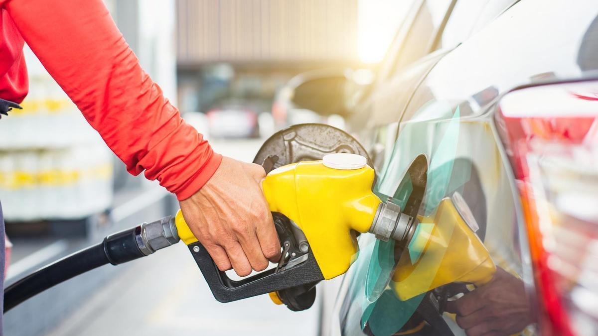 Un hombre pone gasolina.