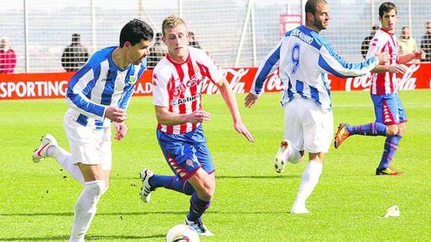 El rojiblanco Álex Barrera presiona al delantero del Leganés Ballesteros durante el partido de ayer en Mareo.