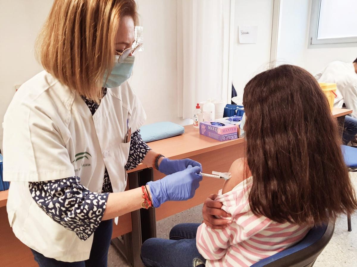 Una joven recibe una vacuna contra el COVID.