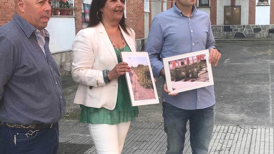 Marina Pineda y César González, acompañados por el vecino Robustiano Iglesias, muestran dos imágenes del mal estado de los patios.