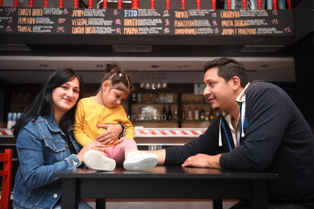 Nadia Pereyra y Fabián López Casco, con su hija Antonella, en su pizzería del barrio coruñés de Os Mallos.