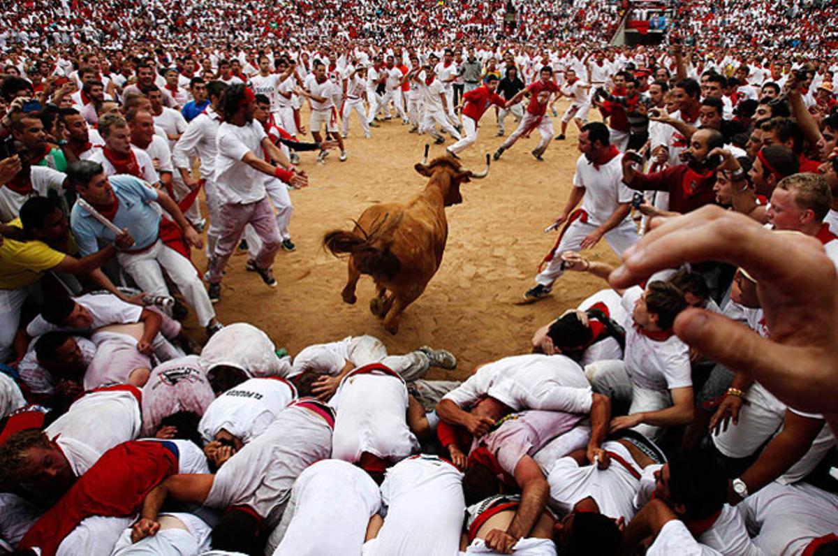 Una vaqueta salta sobre el públic en una plaça de toros durant la segona carrera de les festes de Sant Fermí, a Pamplona.