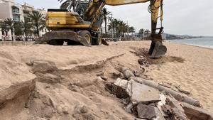 Una grúa retira los restos de antiguas edificaciones que quedaron al descubierto en la playa den Butifarreta de Badalona tras el paso del último temporal