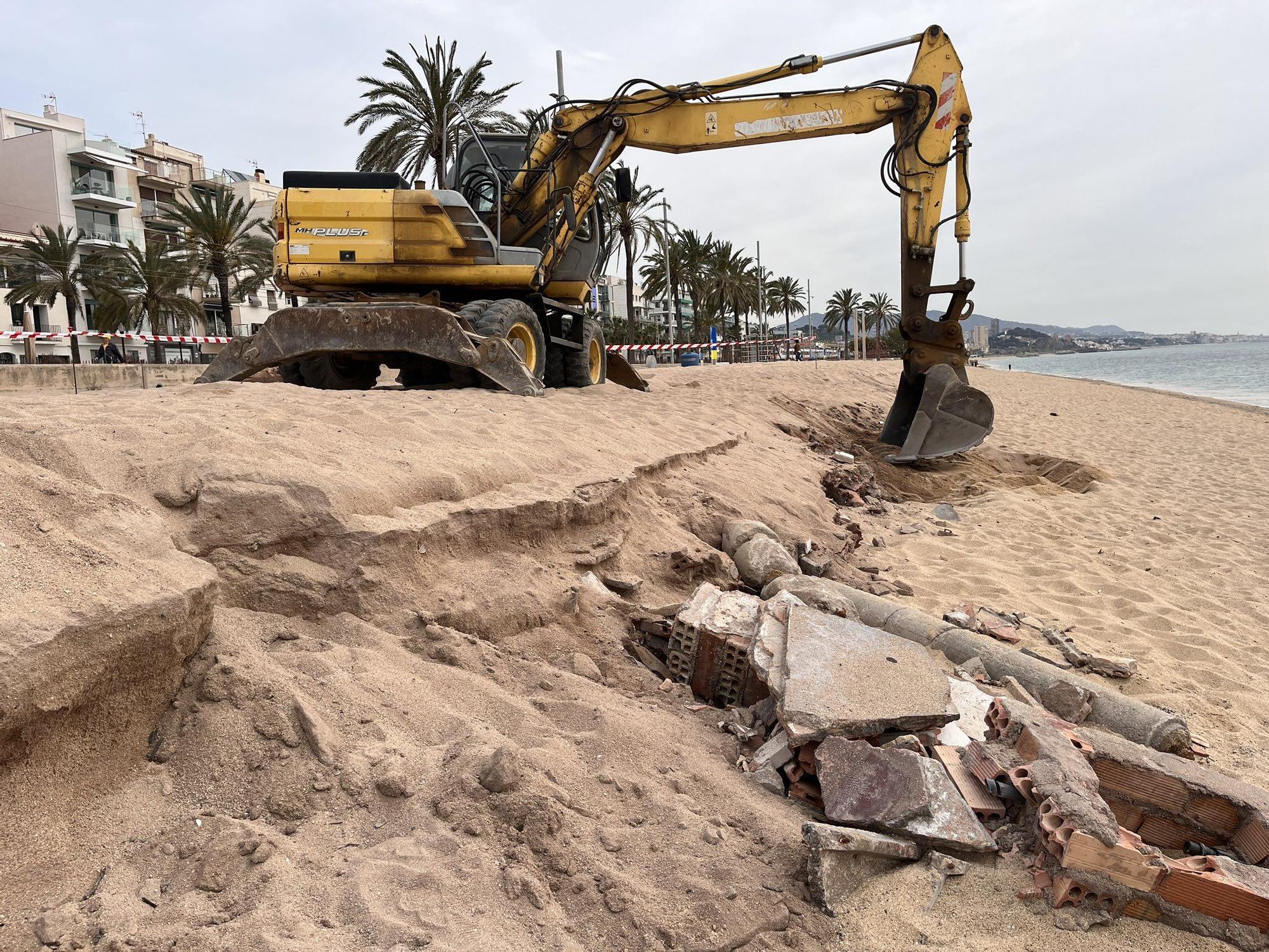 Una grúa retira los restos de antiguas edificaciones que quedaron al descubierto en la playa d'en Butifarreta de Badalona tras el paso del último temporal