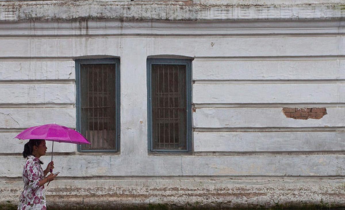 Una dona nepalesa es protegeix de la pluja a Kàtmandu, Nepal.