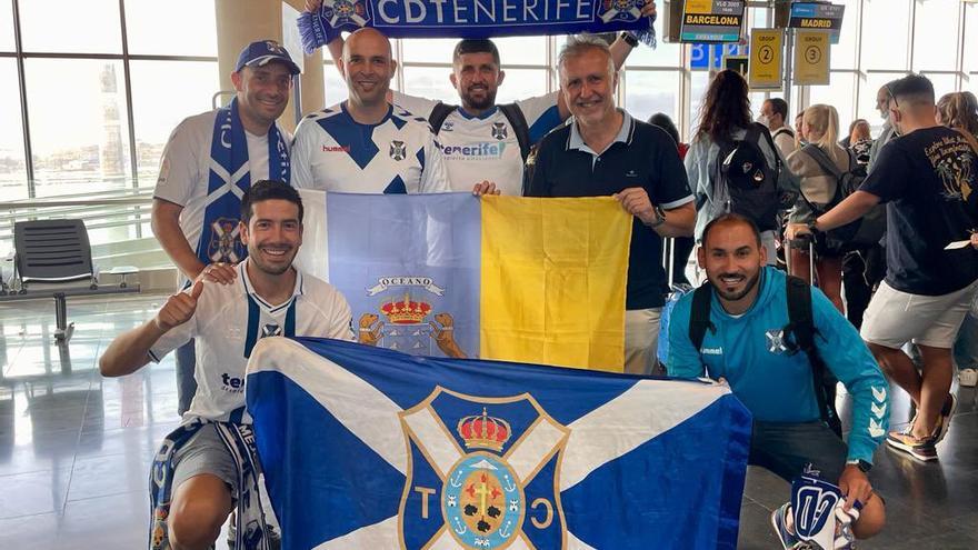 El presidente de Canarias, Ángel Víctor Torres, junto a aficionados del CD Tenerife en el aeropuerto de Los Rodeos esta mañana.