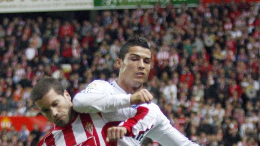 Cristiano Ronaldo pugna con Lora durante el partido en El Molinón de la pasada campaña.