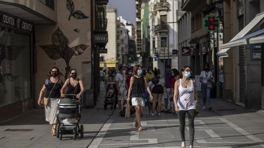 Viandantes con mascarilla pasean por la calle Santa Clara, en Zamora.