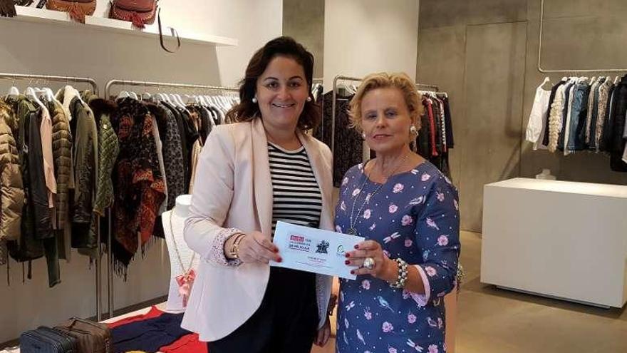 Carmen Davila (izq.) entrega a Gemma Vidal el cheque de 100 euros.