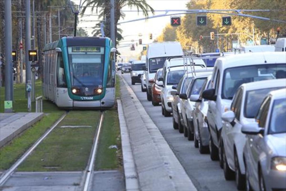 Un tranvía del Trambaix avanza por la Diagonal junto a una hilera de coches. 