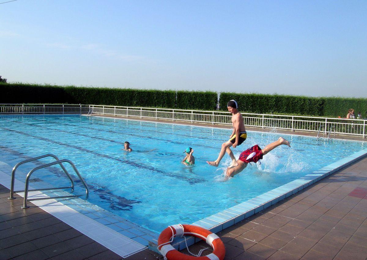 Unos chicos saltan a una piscina.