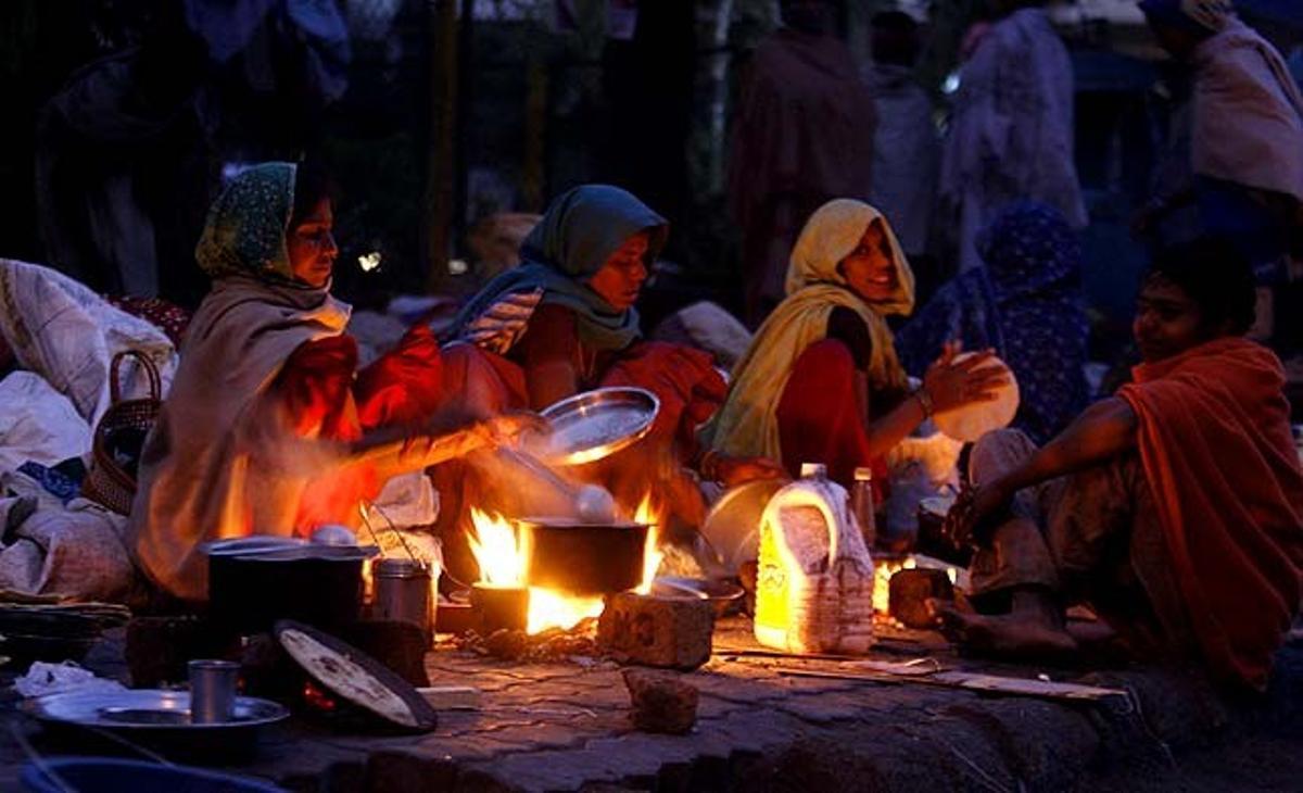Joves sense llar preparen els seus aliments en una carretera a la ciutat occidental d’Ahmadabad (Índia).