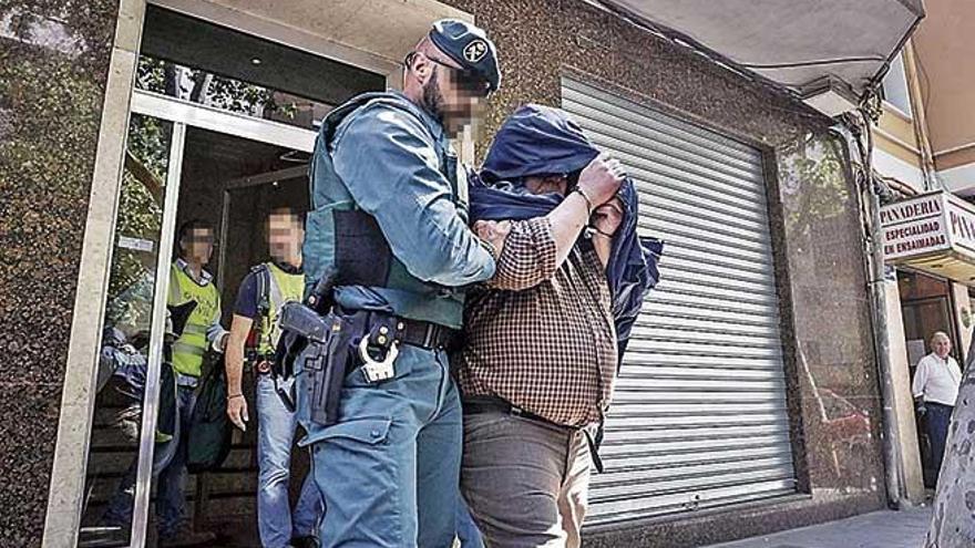 Un guardia civil traslada a uno de los detenidos en la operaciÃ³n &#039;Iron Belt&#039;, en mayo de 2016.