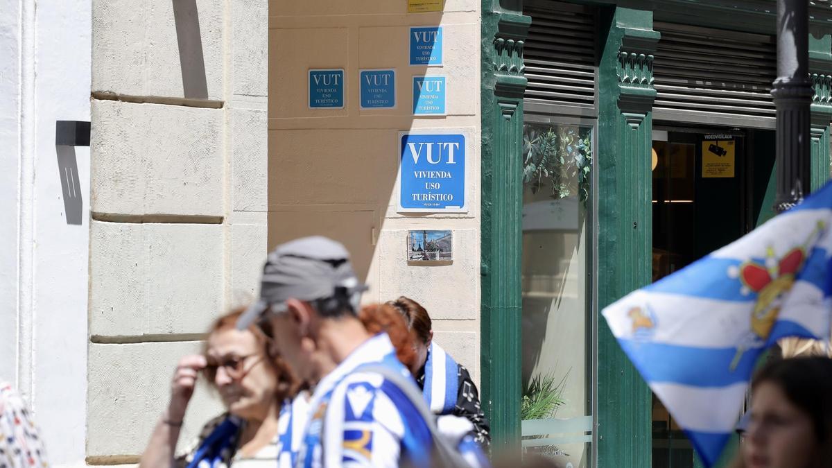 Un portal de la calle Alfonso de Zaragoza con varias placas de viviendas de uso turístico, en mayo.