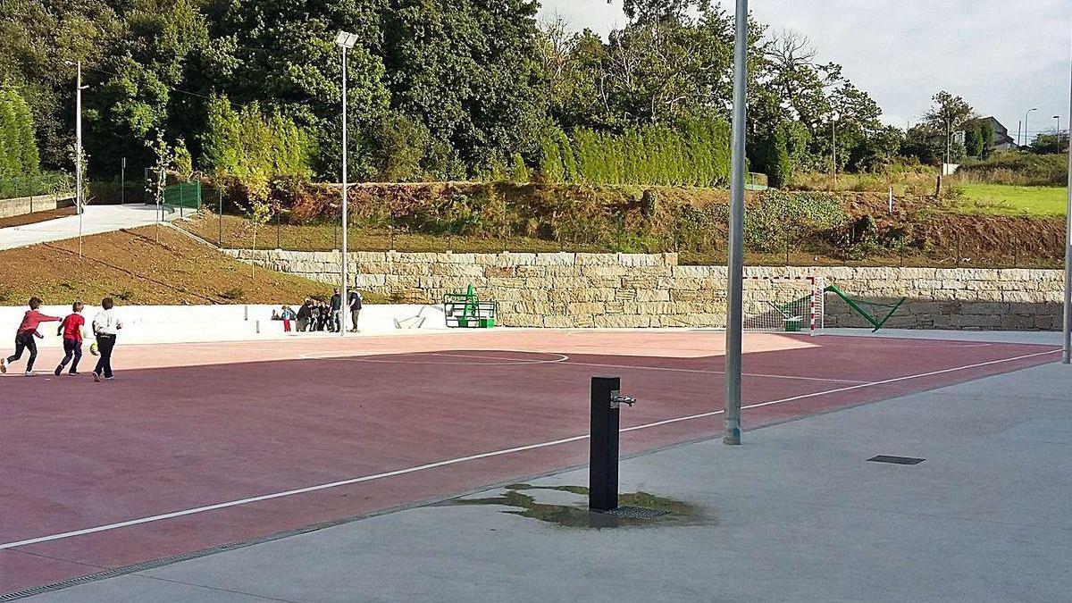 Vista de la pista deportiva del instituto de Carral, en la apertura de puertas en 2015, y fincas anexas.