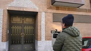 Un informador gráfico toma imágenes del portal donde se encuentra la vivienda en la Travesía de Santoña del distrito de Usera.