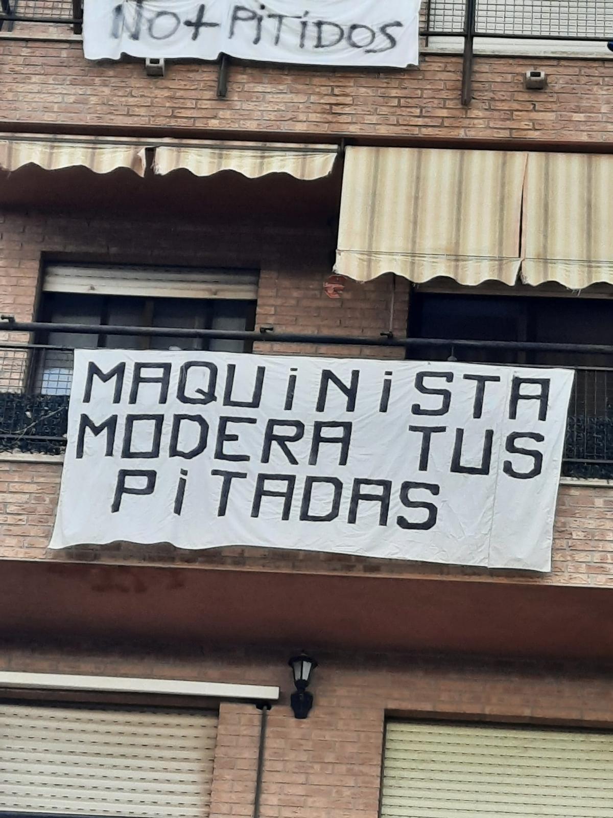 Pancartas en los balcones de las fincas anexas al paso a nivel de Alfafar.