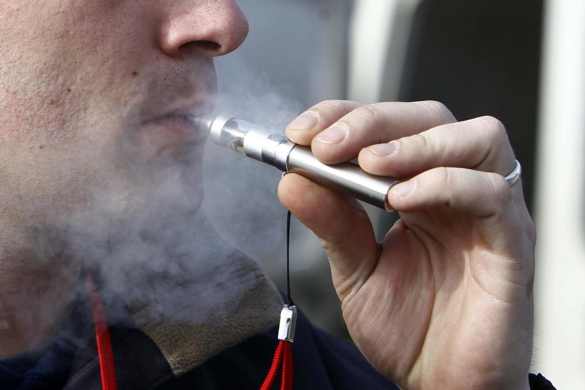 Un joven fumando un cigarrillo electrónico.