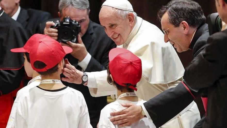 El Papa le hace una carantoña a un chaval durante un encuentro con niños, ayer, en el Vaticano. // G. Lami