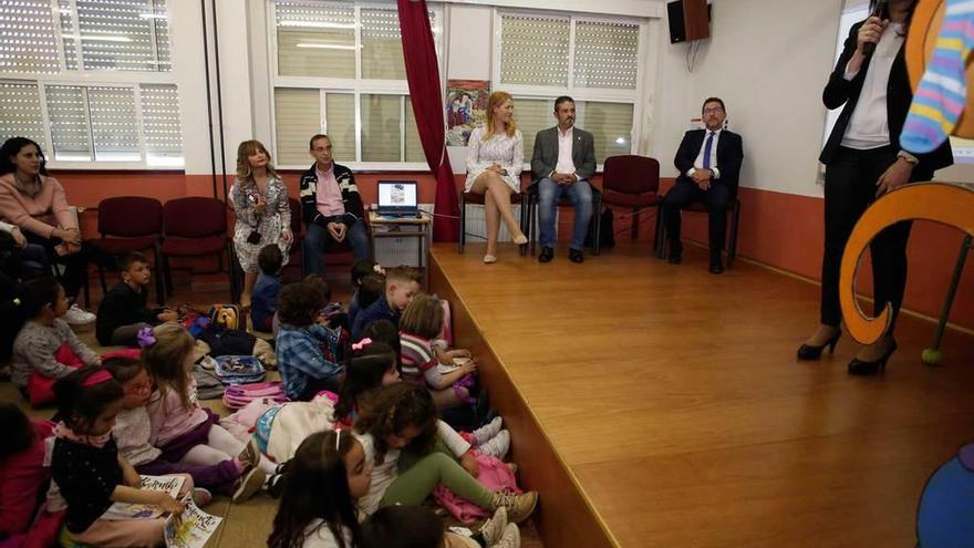 Genaro Alonso, sentado a la derecha, junto a Enrique Tirador y Dulce Victoria Pérez Rumoroso, escucha a Yasmina Triguero en el salón de actos del colegio de Raíces Nuevo.