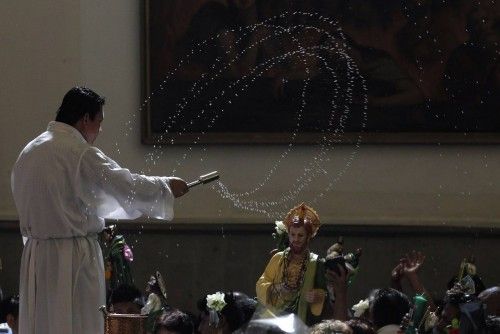 Un sacerdote lanza agua bendita a los fieles en una iglesia de México