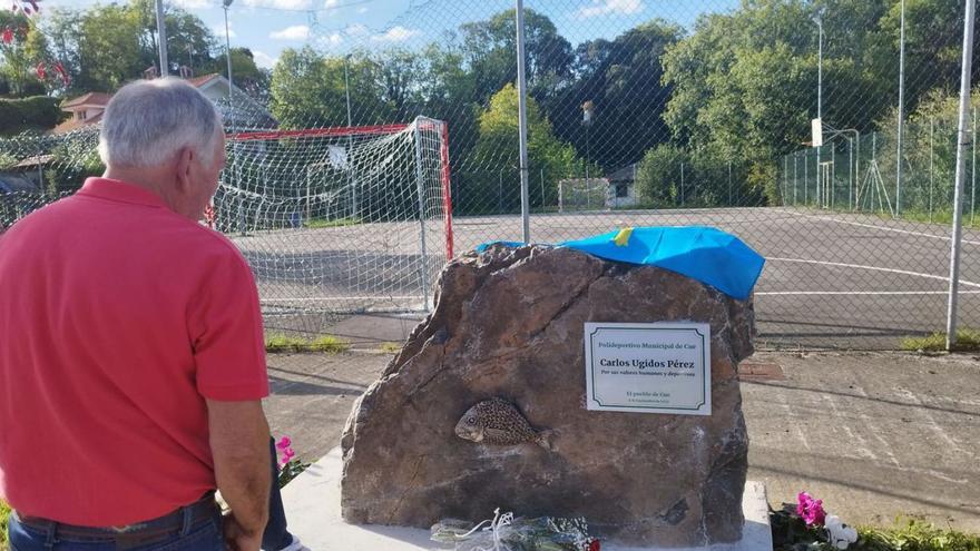 Un vecino observa la placa en honor de Carlos Ugidos. | Julia Quince