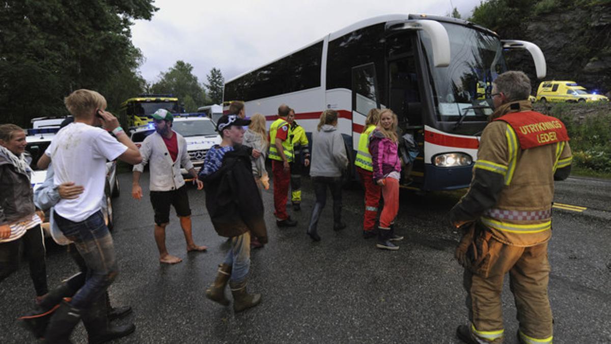 Varios jóvenes se dirigen a un autocar para ser evacuados de la isla de Utoya.