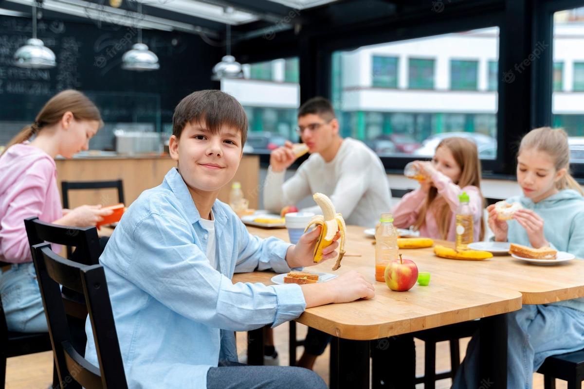 Niños comiendo en un comedor escolar