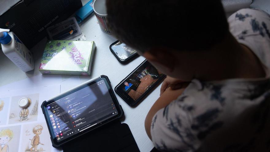 Un niño usa el teléfonomóvil y una tablet.