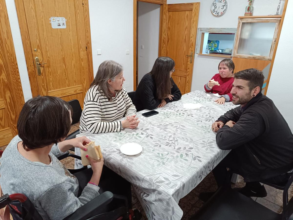 Jesús, Encarnita y Alejandro, en la mesa con Aurora y Viki, que están merendando.