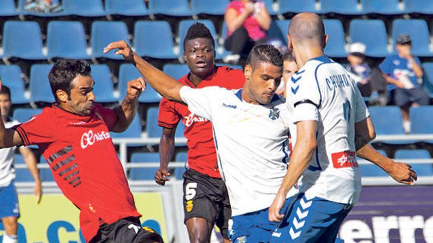 Miguel García intenta detener el avance de dos jugadores del Tenerife.