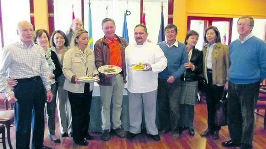 Varios socios del Club Náutico Albatros, mostrando algunos de los platos que ayer comieron en Villaviciosa.