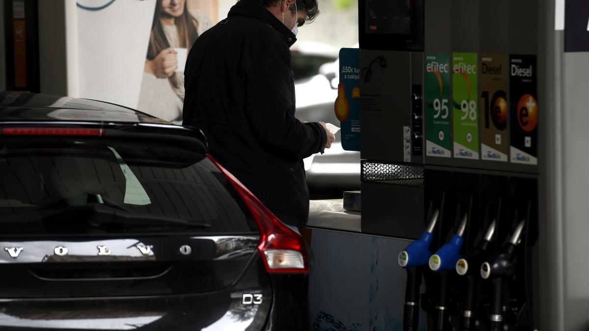 Un home posa benzina al seu cotxe