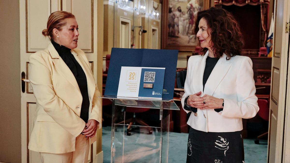 La consejera de Hacienda, Matilde Asián, entrega el anteproyecto de Presupuestos para 2025 a la presidenta del Parlamento, Astrid Pérez (i).