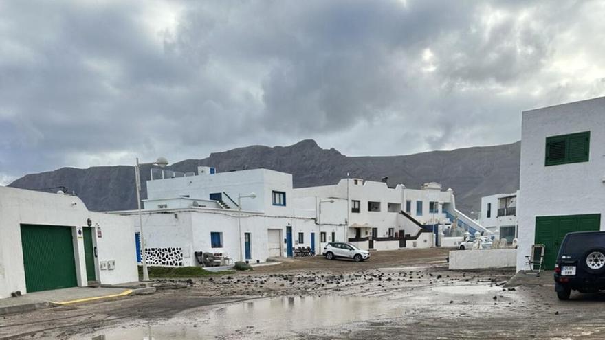 El fuerte oleaje arrasa con la arena de la playa de Caleta de Famara y el mar se introduce en el pueblo