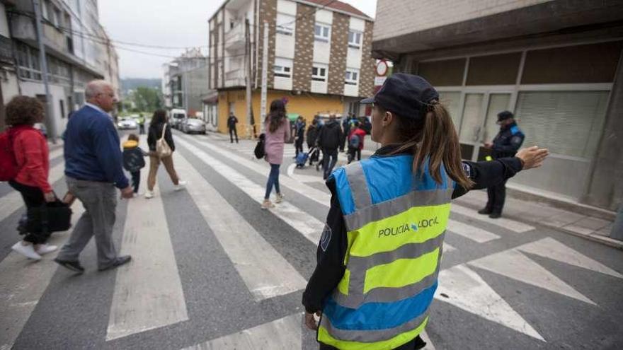 Una policía regula el tránsito a la hora de entrada en el colegio Pérez Viondi. // Bernabé/Cris M.V.