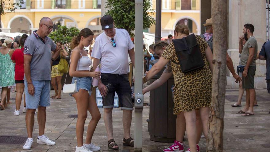 Turistas se refrescan ayer en las proximidades de la plaza Major de Palma.