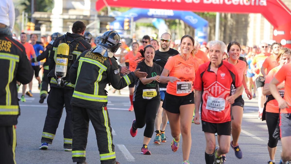 Los bomberos animan a los participantes populares en su carrera