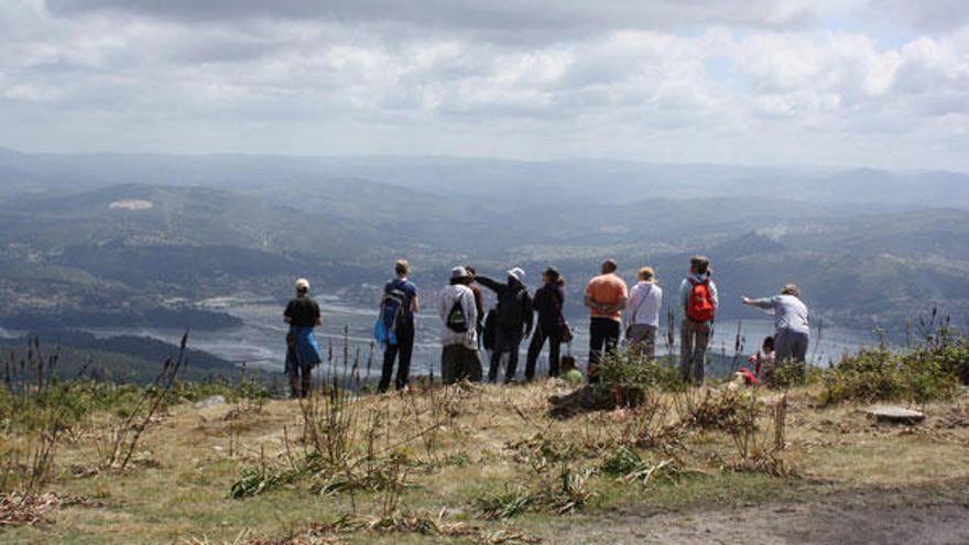 Algunos de los integrantes de la ruta de ayer por los montes del Morrazo observan las espectaculares vistas desde la cima.  // Carmen G.