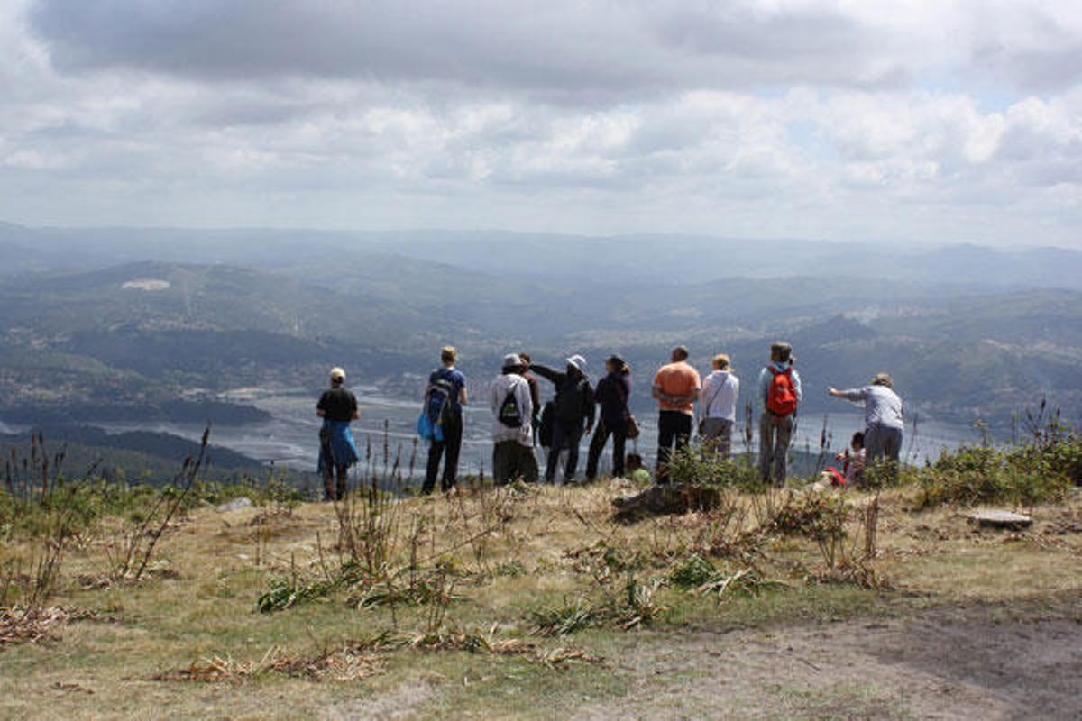 Algunos de los integrantes de la ruta de ayer por los montes del Morrazo observan las espectaculares vistas desde la cima.  // Carmen G.