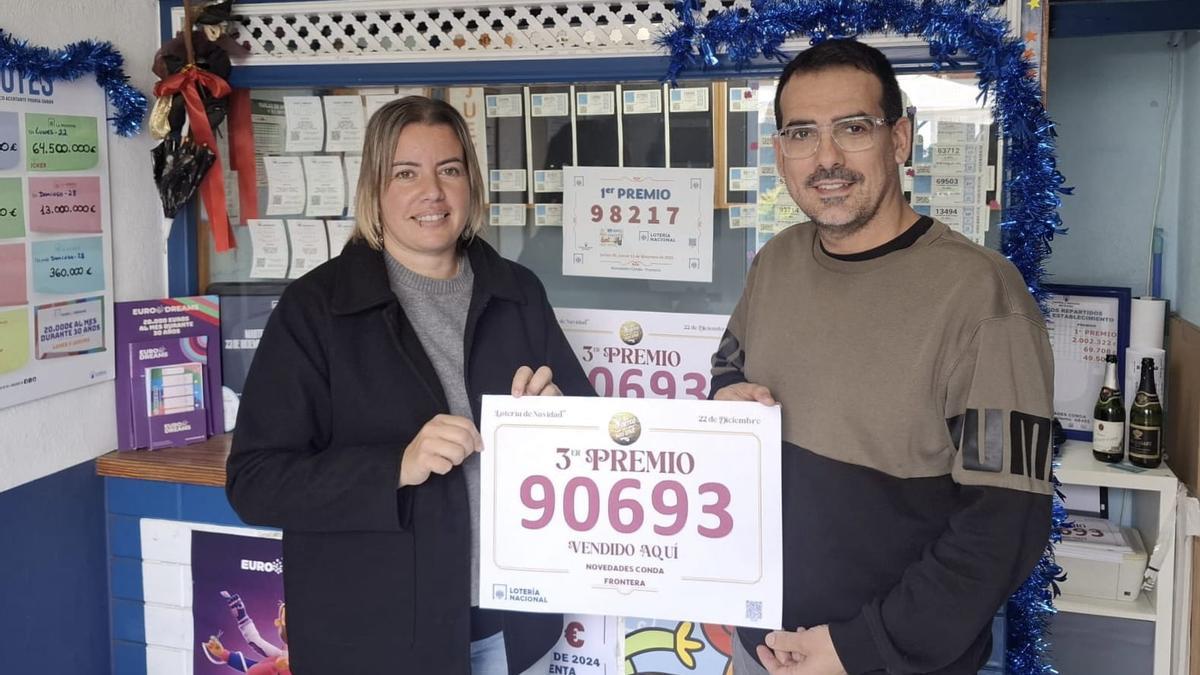 Lidia y Jonay muestran el cartelón del tercer premio del Sorteo de Navidad.