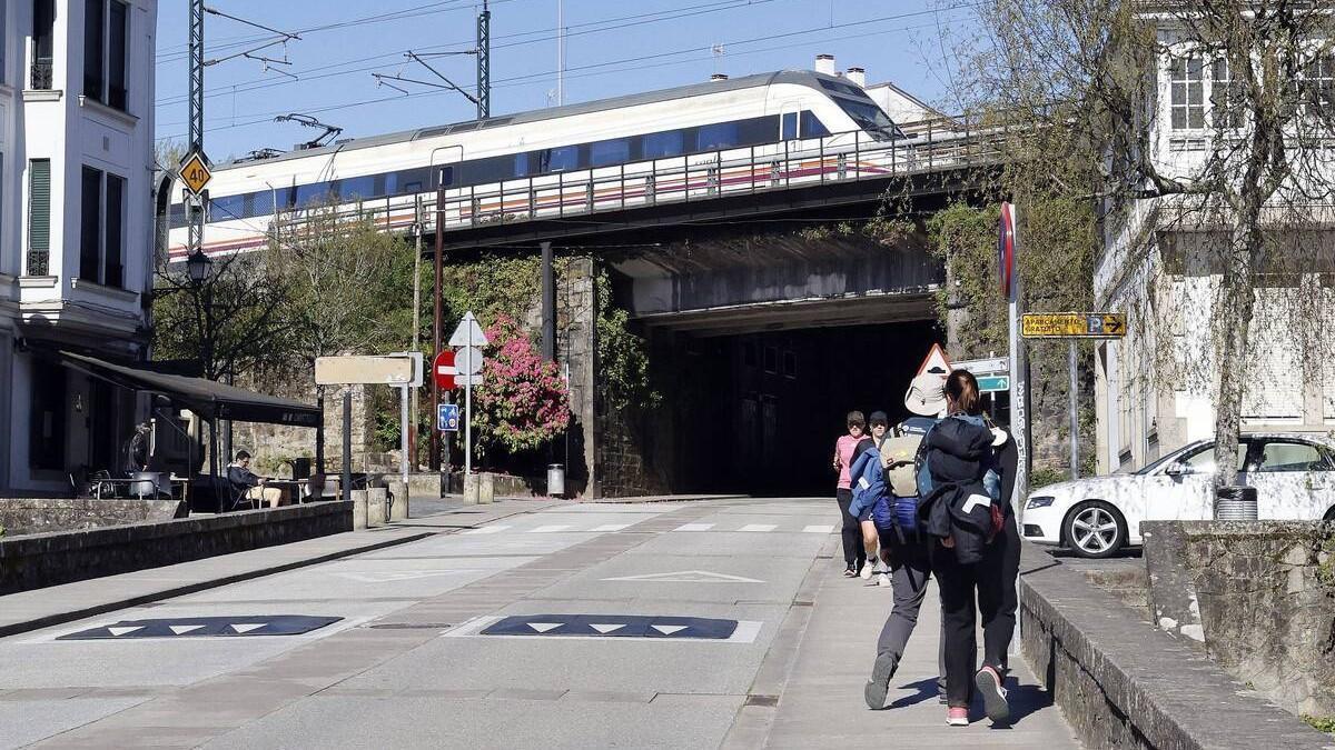 Un tren regional circula sentido A Coruña por el puente sobre el barrio de Sar, en Santiago