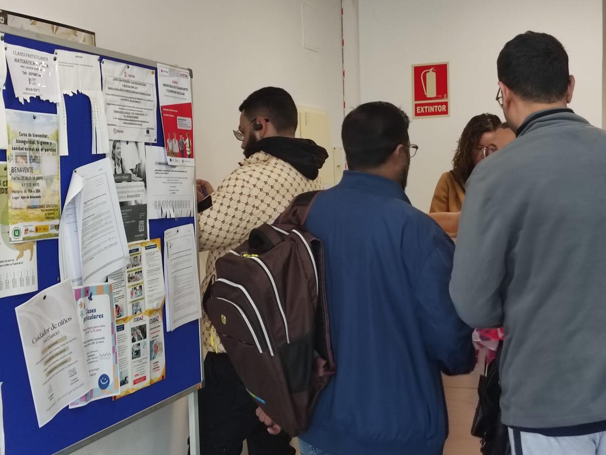 A la derecha dos pakistaníes pidiendo los papeles para iniciar la solicitud y a la izquierda otro ciudadano extranjero con los trámites.
