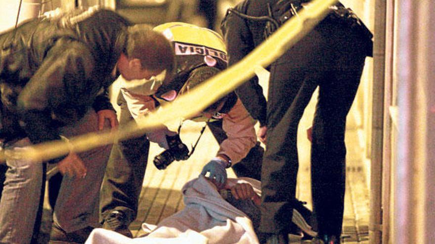 Policías observan, ayer, el cadáver del joven precipitado tras el registro.