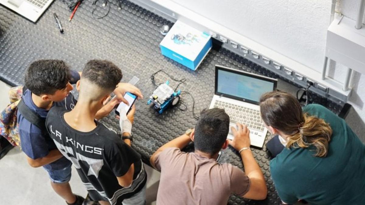 Jóvenes trabajando con aparatos electrónicos.