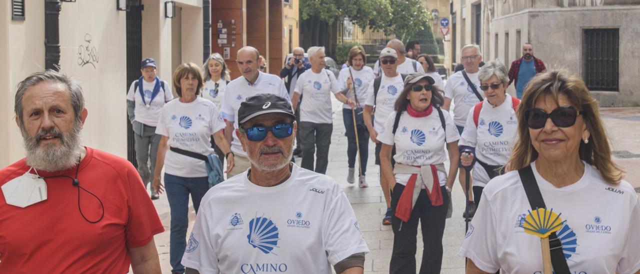 Arriba, por la izquierda, Alfredo García Quintana, Lourdes Campillo, Camilo Sousa y Javier Fernández-Río, ayer, antes de la salida de la prueba. A la izquierda, Lourdes Campillo, a la derecha, portando el relevo y encabezando, ayer, el inicio de la primera etapa de la «Camino Primitivo Non Stop». | Jaime Casanova