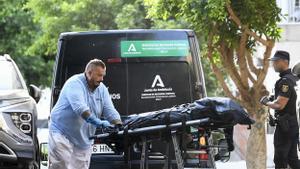 Miembros de los servicios funerarios trasladan el cadáver de la joven asesinada esta tarde en el barrio de Pescadería de Almería, degollada presuntamente por su pareja. 