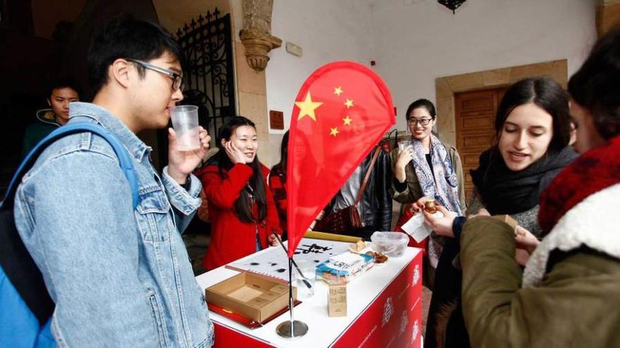 Estudiantes de &quot;Erasmus&quot;, ayer, en el stand de China en el &quot;International Day&quot;, en el edificio histórico de la Universidad de Oviedo.