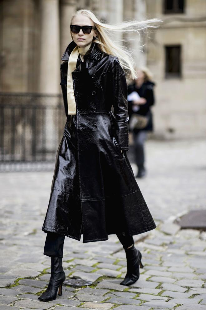 Look del street style de París con gabardina de cuero y botas