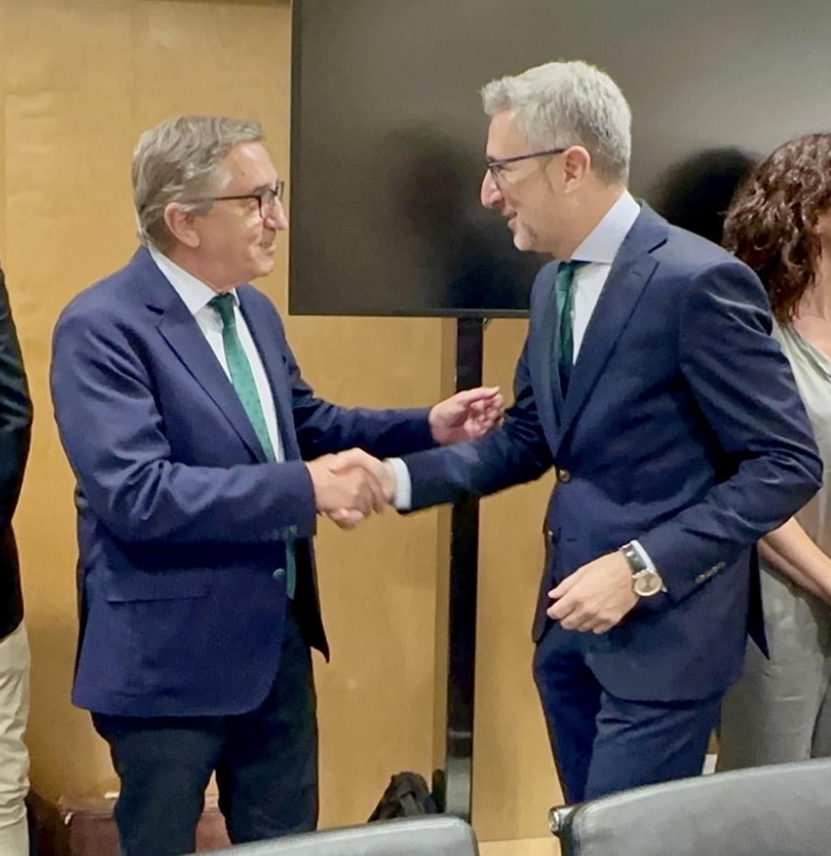 El ministro de Hacienda, Arcadi España, saluda a su homólogo en el Consell, José Antonio Rovira, este lunes en el CPFF en Madrid.